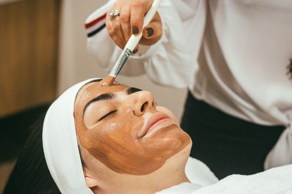 Hands on a face in a clinic, before any gel is named